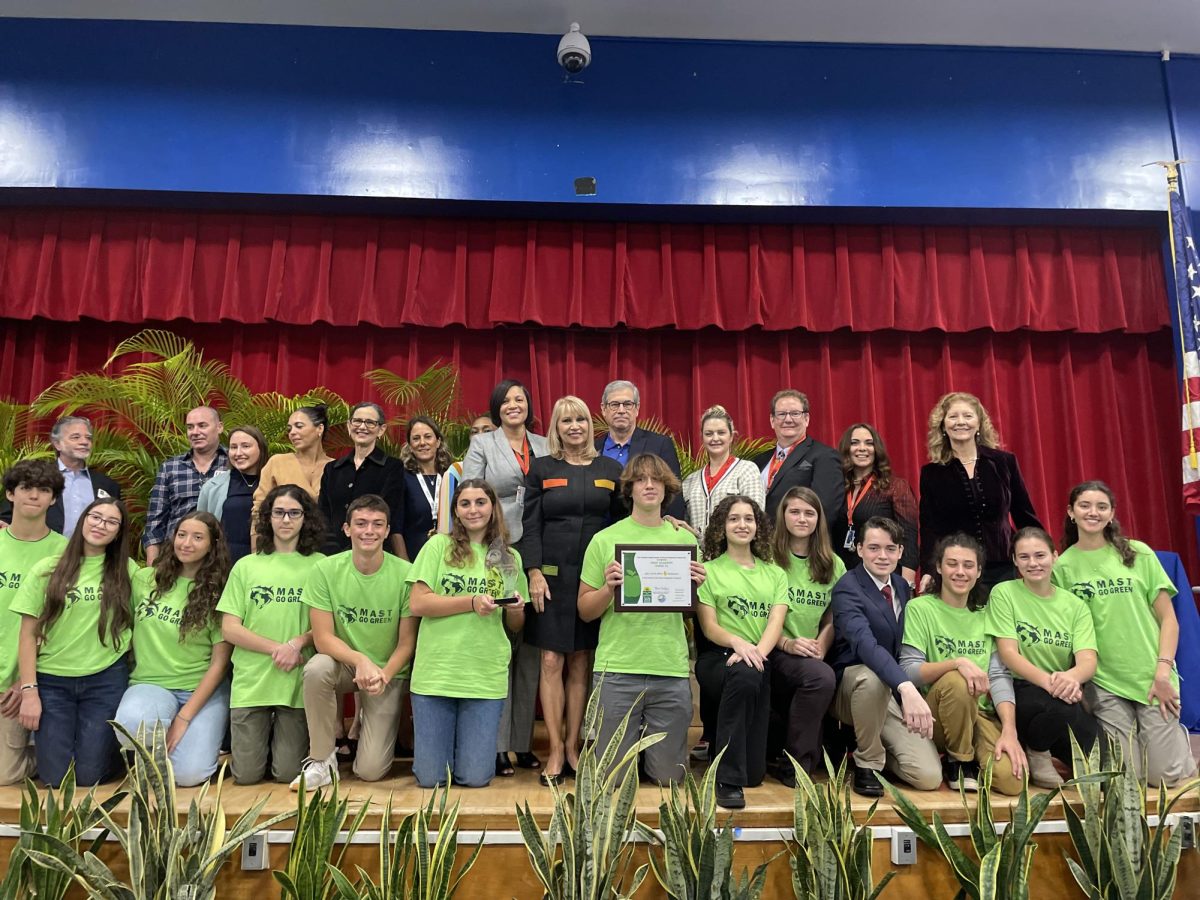 Members of the MAST Academy Green Champions pose with members of the schools staff and administration, as well as members of the community and local government, after receiving the FDEP Gold Apple award in the schools auditorium on Jan. 29, 2023.