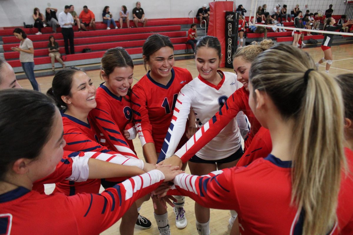 The MAST Academy varsity girls volleyball team huddles up before its match against host Coral Gables Senior High School on Sept. 14, 2023.