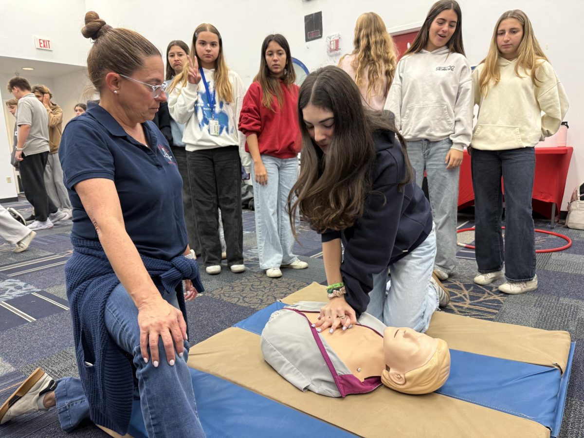 8th grade students practice lifesaving CPR techniques during a mandatory Florida state training session. Photo by Ely Moreno.